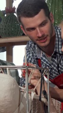 In a lively studio filled with vibrant colors and artistic tools, a dynamic trio of young ceramic artiststwo men and one womanare joyfully sculpting together. Their laughter and shared ideas fill the air as they skillfully mold clay, embodying the