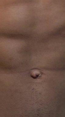 This captivating close-up reveals a sculpted male torso, emphasizing chiseled abs and a robust chest against a sleek black backdrop. The image radiates strength and dedication, celebrating the artistry of the human physique and inspiring admiration