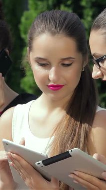 Üç şık iş kadını, dışarıda işbirlikçi bir tartışma içinde, bir tanesi kameraya özgüvenle bakıyor, karizma yayıyor. Şık kıyafetleri ve canlı ifadeleri davetkar bir atmosfer yaratıyor, güçlendirme ve...