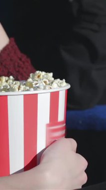 Canlı kırmızı ve beyaz çizgili patlamış mısırı sıkıca kavrayan bir elin yakın çekimi film gecesinin heyecanını yayıyor. Arkadaşlar sinemanın büyüsüyle kaplanırlar. Kahkahalar ve neşeyi paylaşırlar. Lezzetli atıştırmalıkların tadını çıkarırlar.