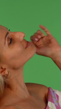 Neşeli, olgun bir kadın saçlarını zarifçe kıvırır. Işıl ışıl gülüşü parlak yeşil renkli arka planı aydınlatır. Bu büyüleyici görüntü onun zarafetini ve canlılığını yakalıyor, muhteşem özelliklerini ve neşeli ruhunu bir anda gösteriyor.