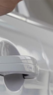 Neşeli, genç bir kadın, ışıl ışıl bir gülümseme ile, yeni sahip olmanın heyecanını somutlaştıran modern bir galeride, çarpıcı yeni arabasının kapısını açıyor. Gösterişli araç, galeri ışıklarının altında parlak bir şekilde parlıyor. Yeni başlangıçları simgeliyor.