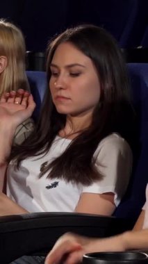 Neşeli, kaş çatan ve ışıl ışıl gözleri olan genç bir kadın, arkadaşlarının sinemada patlamış mısırına uzanmasını inançsızlıkla izliyor. Canlı kırmızı-beyaz çizgili kova hoş, loş aydınlatılmış tiyatro karşısında ortaya çıkar, hoş bir anı yakalar