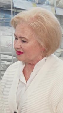 Hoş bir son sınıf çifti, neşe ve sıcaklık saçıyor, parlak, davetkar bir mobilya mağazasından yumuşak keten seçiyorlar. Çekici sohbetleri ve şefkatli gülümsemeleri samimi bir atmosfer yaratıyor, sevgilerini gösteriyor.