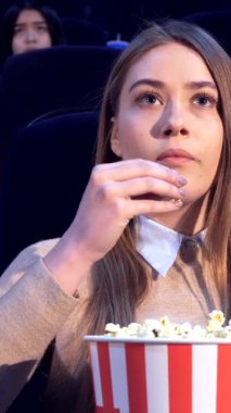 Güzel, genç, beyaz bir kadın karanlık bir tiyatroda oturur, patlamış mısırı dudaklarına nazikçe bastırır, büyünün etkisiyle büyülenir. İfadesi neşe ve beklenti saçıyor. Etrafı film izleyicileriyle çevrili. Canlı bir atmosfer yaratıyor.