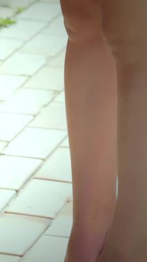 Üç çift şık ayak, modaya uygun sandaletlerle süslenmiş, neşeli bir kaldırımda güneşleniyorlar, neşe ve dostluk saçıyorlar. Bu nefis sahne, genç macera ve arkadaşlığın özünü yansıtıyor. Bu şık kızlar, genç bir kızı kucaklarken...