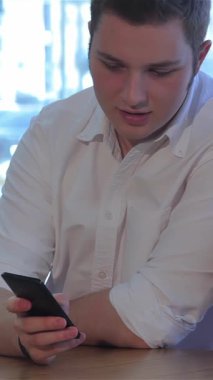 Yumuşak doğal ışıkla yıkanmış rahat bir kafede, saçlarında canlı bir halka olan çekici bir kadın pipetle ferahlatıcı bir kokteylin tadını çıkarırken, beyaz, çıtır bir gömlek giymiş yakışıklı bir adam akıllı telefonuyla özümseniyor. Bu samimiyet