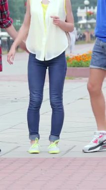 Güneşli bir günün sıcaklığında güneşlenen üç genç arkadaş, akıllı telefonlarıyla selfie çekerken birbirlerine neşeyle gülüyorlar. Canlı kıyafetleri ve tasasız ifadeleri mutluluk saçıyor, arkadaşlığın ve yaz eğlencesinin özünü somutlaştırıyor.