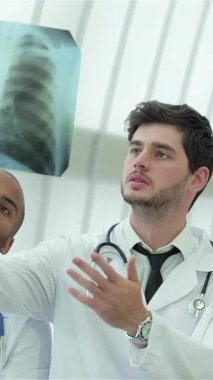 Pürüzsüz, iyi aydınlatılmış bir hastanede, üç kendine güvenen doktor ve bir kadın, sağlıklı akciğerlerin röntgenini inceliyor. Odaklanmış ifadeleri ve beyaz önlükleri hasta bakımına olan bağlılıklarını ve anlayışlarını yansıtıyor.