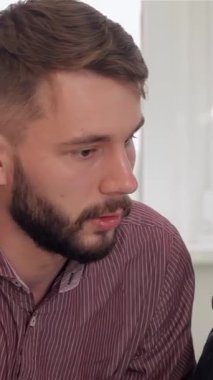 Aydınlık ve modern bir ofiste, üç adam bir dizüstü bilgisayarın etrafında ortak bir tartışma içinde, yenilikçi fikirlerin değişimine yol açıyorlar. Gözlüklü esmer adam sezgilerini paylaşırken coşkuyla ışıldıyor.