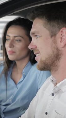 Sevinçli, sakallı, beyaz bir adam yeni şık bir arabanın içinde, saf bir heyecan saçarak başparmağını kaldırıyor. Onun yanında, onun çarpıcı esmer kız arkadaşı sevinçle ışıldıyor, her ikisi de bu önemli kilometre taşını kucaklarken mutluluk saçıyor.