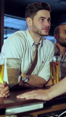 Kahkahalarla dolu canlı bir barda, dört genç işadamı büyük ekranda bir futbol maçının heyecanını kutlamak için buzlu bira bardaklarını havaya kaldırıyor. Bulaşıcı heyecanları ve yoldaşlıkları canlı atmosferde yayılıyor.