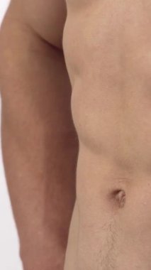 Yırtık tişörtsüz kaslı bir adam kaslı karın kaslarını kasarak güç ve kararlılık saçıyor. Bu güçlü görüntü fitness özünü somutlaştırıyor ve izleyicilere kendi sağlık hedeflerinin peşinden koşmaları için ilham veriyor.