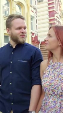 Neşeli genç bir çift, mutlu şehir manzarasında el ele dolaşır, yüzleri mutluluk ve macerayla parlar. Gündelik yaz kıyafetleri içinde, renkli mimari ve vızıltılarla çevrili, keşif ruhunu somutlaştırıyorlar.