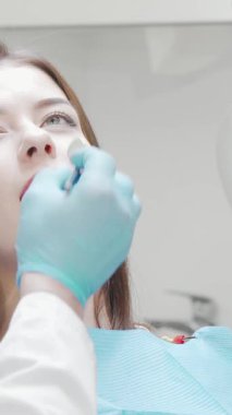 Göz kamaştırıcı gülümsemesini kameraya gösteren ışıl ışıl genç bir kadın diş kontrolünden sonra saf neşe saçıyor. Parlak, modern klinik düzenlemesi, kendine olan güvenini ve memnuniyetini arttırıyor.