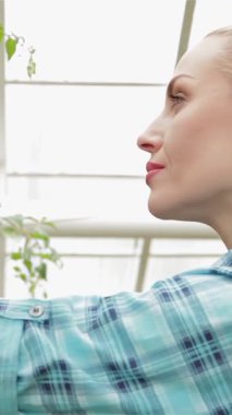 Güneşli bir bahçe merkezinde, genç sarışın bir çiçekçi canlı bitkileri tutkuyla budar, bahçeciliğe olan aşkını somutlaştırır. Işıl ışıl bir gülümseme ile, bu çekici beyaz kadın, yeşilliği zarifçe şekillendirir, etrafındaki güzelliği büyütür.