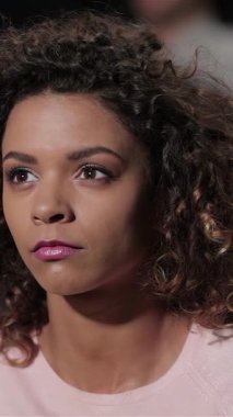 Kıvırcık saçlı çarpıcı bir kız, rahat bir tiyatroda oturur. Ürpertici bir korku filmine daldığında, geniş gözleri belirsizliği yansıtır. Etrafı arkadaşlarla çevrili, atmosfer heyecanla dolu, kahkahalarla dolu ve çatırdayan