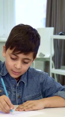 Çekici bir baba ve küçük esmer oğlu masada çok hoş bir çizim seansına dalmışlar. Gülümsemeler ve yaratıcılık saçıyorlar. Genç Afrikalı Amerikalı adam heyecanlı çocuğuyla dikkatle etkileşime giriyor.