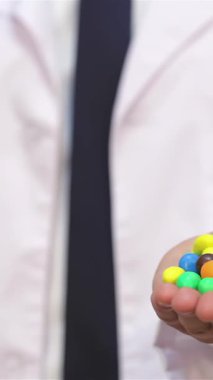 Kıtır beyaz önlüklü ilgili bir erkek doktor, hoşgörü ve sağlıklı beslenme arasındaki uyumu sembolize eden parlak bir elmanın yanında hoş bir dizi tatlı sunar. Yumuşak beyaz bir arkaplanda geçen bu ilgi çekici sahne,