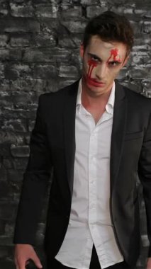 Zarif siyah takım elbiseli tehditkar bir vampir, kaygı verici bir şekilde siyah tuğla bir duvara karşı duruyor, solgun yüzü kanla çizilmiş ve perili bir bakışla. Bu tüyler ürpertici tasvir Cadılar Bayramı 'nın özünü özetliyor.