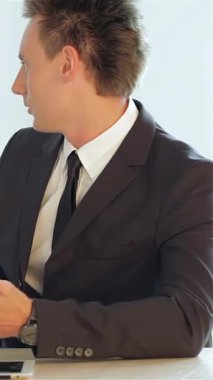 Gösterişli, modern bir ofiste, terzi kıyafeti giymiş iki profesyonel işadamı tartışmalarını başarılı bir ortaklığı sembolize ederek belirleyici bir tokalaşmayla bitiriyor. Parlak, havadar ortam pozitif ve hırslı bir şekilde yansıyor.