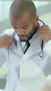 Gıcır gıcır beyaz bir önlük ve steteskop giyen odaklanmış bir doktor, şık ve çağdaş bir klinikte müşterisiyle anlamlı bir istişare yapmadan önce kıyafetlerini düzeltiyor. Davetkar atmosfer güvenin önemini vurguluyor.