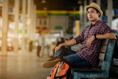 Bir gezgin ile Asya yakışıklı adam seyahat otobüs istasyonunda sırt çantası ile. Seyahat kavramı.