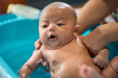 Köpük kabarcıkları ile oynarken banyo mutlu gülen bebek. 
