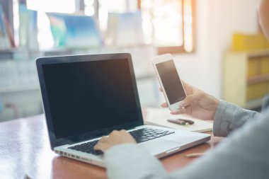 Office, işkadını kadar güzel genç kadın akıllı telefon ve dizüstü ekran kullanma kapatın
