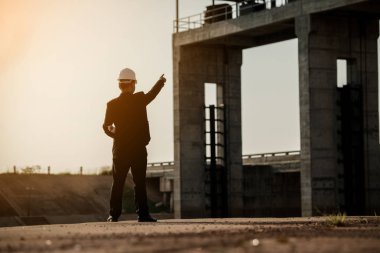 İş Sanayi, insanlar, kişisel ve kariyer büyüme, gelişme ve potansiyel kavramları. Site içinde çalışan bir baraj site.silhouette mühendislik planı seyir işadamı mühendisi