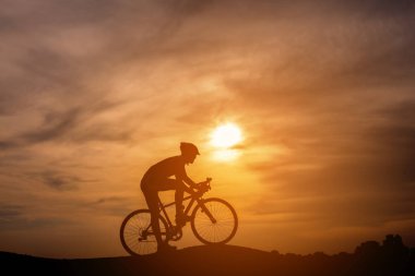 Sunset Bulvarında bir bisiklet sürme genç adam silüeti