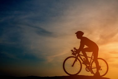 Sunset Bulvarında bir bisiklet sürme genç adam silüeti