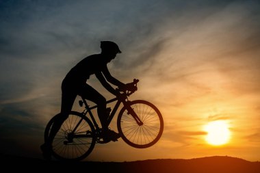 Sunset Bulvarında bir bisiklet sürme genç adam silüeti