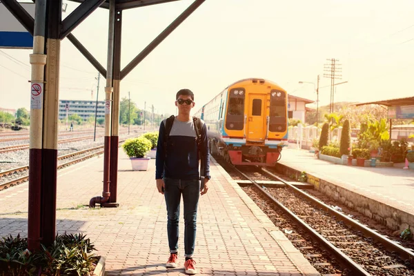 traveler man standing at the train station with a traveler. Travel concept.