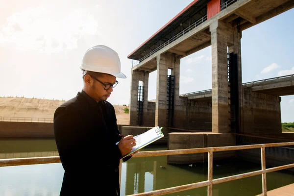 Business Industrial,People,personal and career growth, progress and potential concepts.Businessman engineer looking blueprint in a dam site.