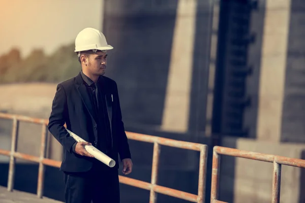 Business Industrial,People,personal and career growth, progress and potential concepts.Businessman engineer looking blueprint in a dam site.