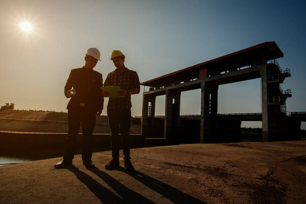 Инженеры, деловые встречи, архитектурные чертежи. Концепция инженерных постоянных заказов для строительных бригад для безопасной работы
