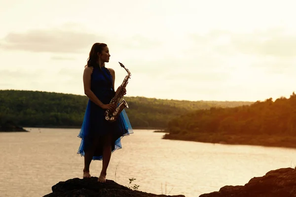 Woman playing saxophone sax at sunset,concept lifestyle music
