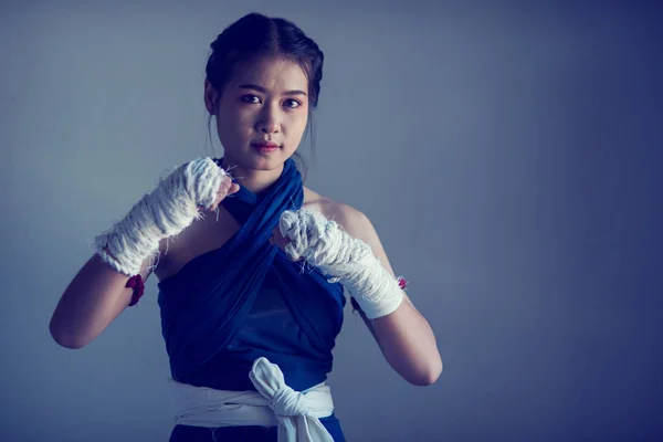 Closeup female hand of boxer with white boxing bandages. Fists of fighter before the fight or training in the gym