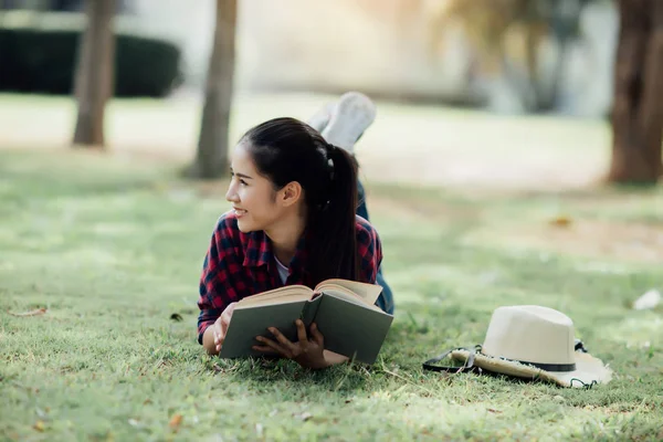 Bella ragazza nella foresta d'autunno leggendo un libro.woman tiene un boo — Foto Stock