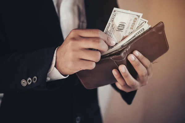 Hombre de negocios ahorrando dinero, hombre llevando una billetera en la mano, la muñeca — Foto de Stock