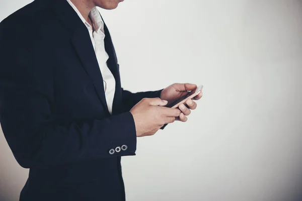 Affärsman med hjälp av smart telefon på grå bakgrund och kopiera utrymme — Stockfoto