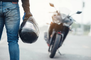 Motosiklet kasklı yakışıklı motosikletçi.