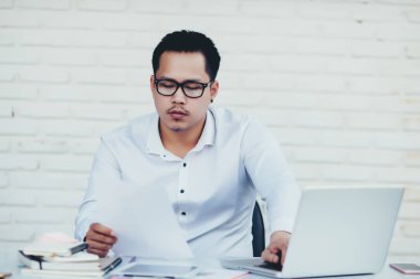 Yaratıcı ofiste çalışan yakışıklı genç bir iş adamı.