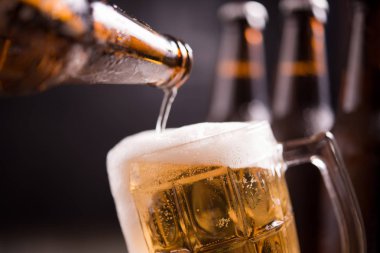 Koyu arka planda cam ve buz ile cam şişe bira