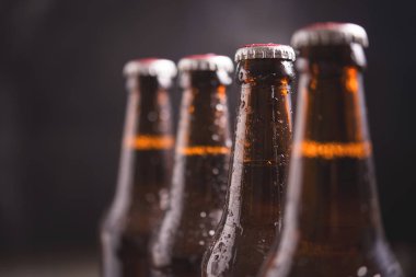 Karanlık arka planda buz ile cam şişe bira kapatın