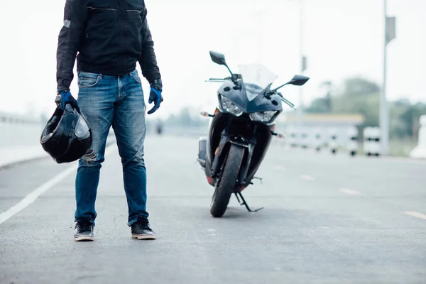 Motociclista bonito com capacete nas mãos da motocicleta — Fotografia de Stock