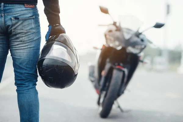Motosiklet kasklı yakışıklı motosikletçi.