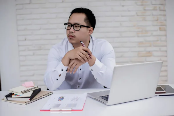 Porträtt av en ung affärsman som sitter vid sitt skrivbord på kontoret — Stockfoto