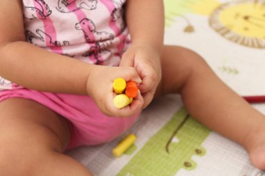 Elinde tebeşir ve kalemle oynayan çocuk